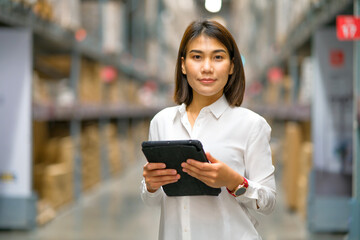 Fototapeta premium Young asian female in holding tablet computer in warehouse store