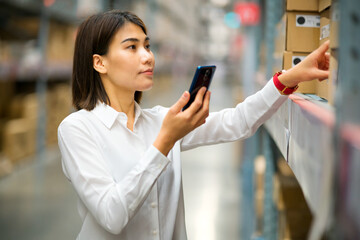 Young asian female is using smart phone searching and check label on goods carton
