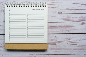 September planner and organizer 2022 calendar on wooden desk. Directly above.