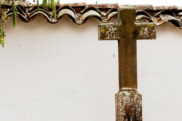 Old catholic cross on the wall made of stone