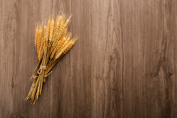 Spikelets of wheat on old wooden table background