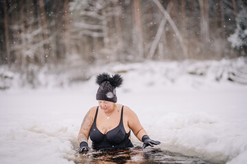 Beautiful chubby girl in winter swim, winter hardening therapy, ice cold swim in the river