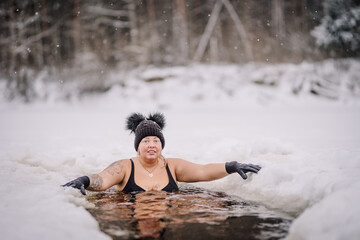 Beautiful chubby girl in winter swim, winter hardening therapy, ice cold swim in the river