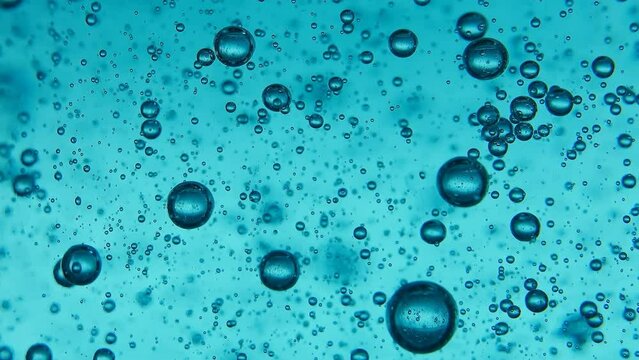Bubbles in blue clean purified water close-up rise to the top. Bubbles under water. Super slow motion 4k macro video.