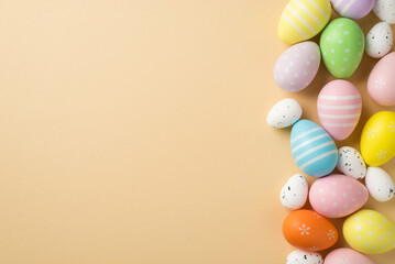 Top view of few multicolored pastel and white middle and small eggs situated on isolated beige background with copyspace