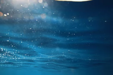 Fotobehang ocean underwater rays of light background, under blue water sunlight © kichigin19