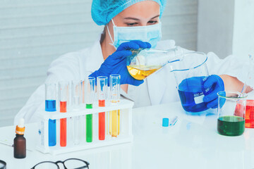 Scientist in uniform holding beaker and test tube have chemical liquid for testing chemical reaction.