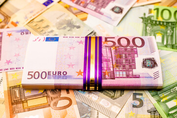 A pack of European currency lies on the background of the Euro
