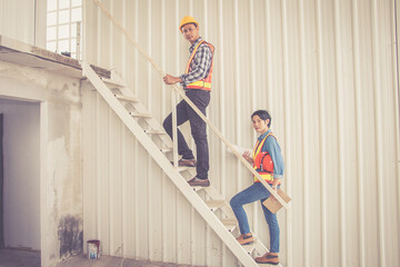 Worker team standing and look building under construction on staircase at construction site..