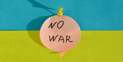 A note with a call to stop the war, attached with a yellow stationery button on the background of...