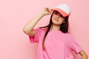 cheerful young girl with a cap on her head in a pink t-shirt