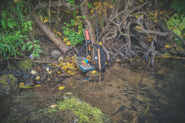 A fly box with flies surrounded by gear.
