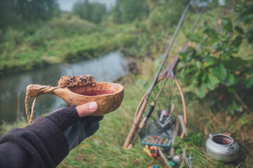 Drink tea from kuksa with a muesli bar.