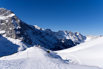 Aerial view of mountain panorama at the Swiss Alps seen from ski resort Engelberg, focus on background. Photo taken February 9th, 2022, Engelberg, Switzerland.