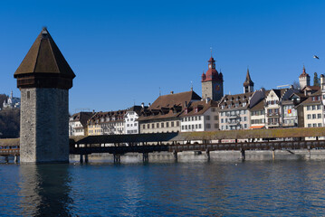 Medieval old town of Luzern with famous covered wooden Chapel Bridge (German: Kapellbrücke) and stone water tower on a sunny winter day. Photo taken February 9th, 2022, Lucerne, Switzerland.
