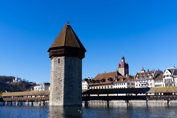 Medieval old town of Luzern with famous covered wooden Chapel Bridge (German: Kapellbrücke) and stone water tower on a sunny winter day. Photo taken February 9th, 2022, Lucerne, Switzerland.