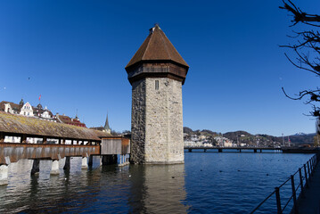 Fototapeta na wymiar Medieval old town of Luzern with famous covered wooden Chapel Bridge (German: Kapellbrücke) and stone water tower on a sunny winter day. Photo taken February 9th, 2022, Lucerne, Switzerland.
