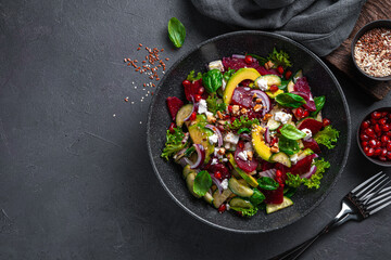 Salad with beetroot, avocado, cucumber and feta seasoned with pomegranate, nuts, flax seeds and...