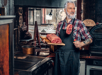 Gray haired butcher and his job in old fashioned meat shop