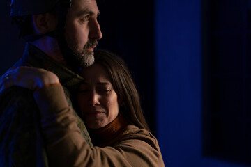 Sad woman crying when hugging her military husband and saying-goodby to him.