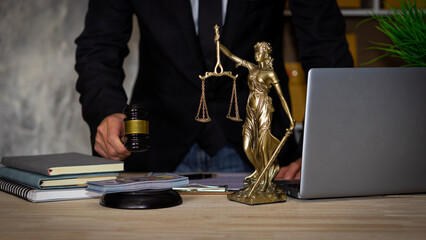 legal concept judge's hammer Statue and scales of justice old courtroom library, wooden table,...