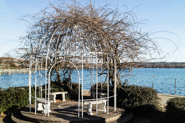Three empty benches in a waterfront gazebo