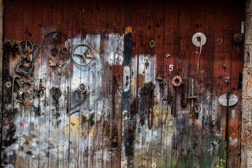 Vieille porte de garage décorée avec de multiples accessoires automobile formant un tableau original et coloré