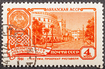 Postage stamp printed in the Soviet Union in 1961. View of Rustaveli Avenue in the capital of Abkhazia Sukhumi in 1961. Coat of arms of socialist Abkhazia within the USSR. Retro and vintage. Close-up