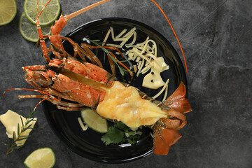 Top view of Painted Spiny Lobster baked with cheese on black table background. Seafood concept.