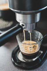 coffee machine pouring double espresso shot in clear coffee glass, coffee break at home
