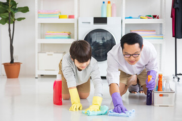 Asian father and son help each other to clean the floor for daily routine chores and housekeeping