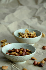 Close-up of two small ceramic bowls with nuts on a Kraft paper background