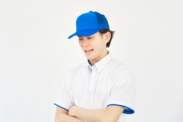 男性　帽子とポロシャツのユニフォーム　落ち込む　白背景