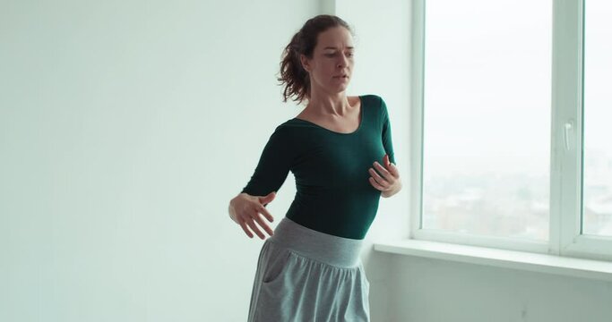 Spiritual dance. Active meditation. Fitness yoga. Home exercise. Inspired graceful woman enjoying movement energy in light studio interior.