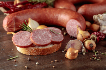 Sandwich with salami on a old wooden table.