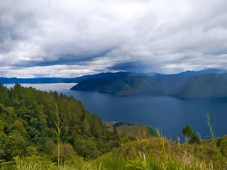 Fototapeten Lake Toba is an amazing natural wonder located on the island of Sumatra. The natural beauty of Tao Toba offers the charm of green mountains spoil the eyes and clean air that is soothing. © Hans