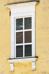 Classic white window in a yellow wall