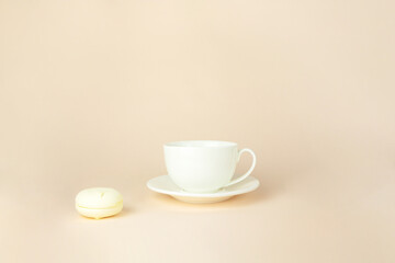 Fototapeta na wymiar French delicate dessert for Breakfast with porcelain white coffee cup mug on beige pastel background.