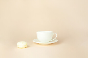 Fototapeta premium French delicate dessert for Breakfast with porcelain white coffee cup mug on beige pastel background.