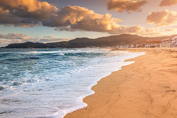 Dramatic panoramic view of iconic Sarti resort town and famous long and empty sandy beach at sunset time. Vacation on Halkidiki, Greece