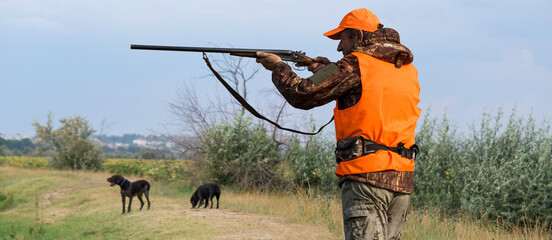 Hunter man in camouflage with a gun during the hunt in search of wild birds or game. Autumn hunting...