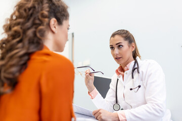 Young female professional doctor physician consulting patient, talking to adult woman client at medical checkup visit. diseases treatment. medical health care concept