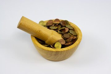 Financial Concept - Coins in a mortar grinded by a pestle