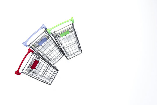 Three grocery baskets with colored handles on a light background top view. The concept of business, sales and retail.