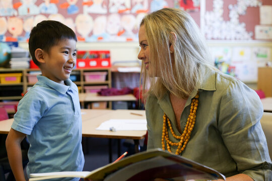 Female teacher speaking to a happy student