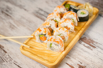 Bright Japanese rolls with shrimp, ginger and wasabi, top view.