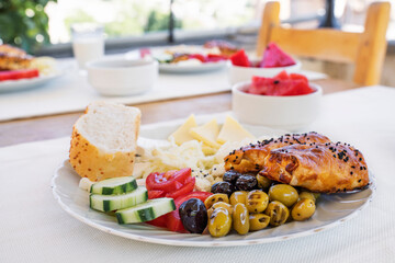 Assorted cheeses and olives, served with vegetables. Traditional Turkish food for breakfast in...
