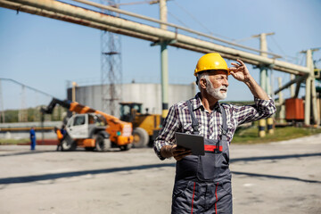 The worker is checking on works at the factory.