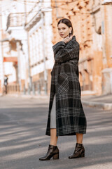 Obraz premium Fashionable girl walking down the street in a European city in a stylish coat