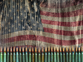 Weapon ammo on an old wooden background with US flag - photo with copy space.